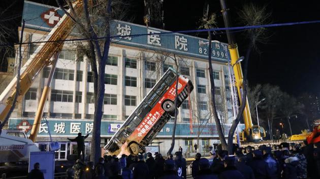 A bus that tipped into a chasm is lifted up as rescue workers look for victims in Xining, China. The bus plunged through a collapsed section of the road, killing six people. (Ma Minyan/AP) A bus that tipped into a chasm is lifted up as rescue workers look for victims in Xining, China. The bus plunged through a collapsed section of the road, killing six people. (Ma Minyan/AP)