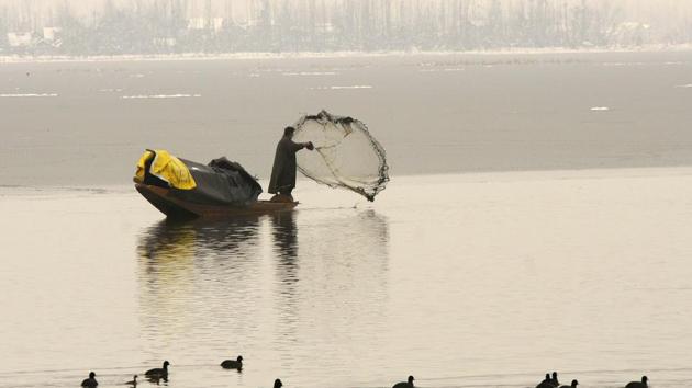 A fisherman casts a net from his boat on the partially frozen waters of the Dal Lake in Srinagar, Jammu and Kashmir. (Waseem Andrabi / Hindustan Times) A fisherman casts a net from his boat on the partially frozen waters of the Dal Lake in Srinagar, Jammu and Kashmir. (Waseem Andrabi / Hindustan Times)