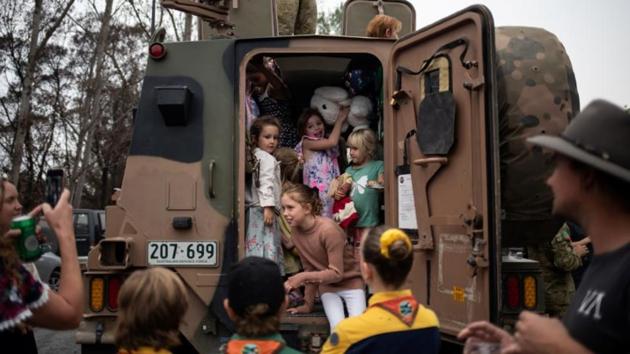 Children play inside an Australian Army vehicle that was expedited to help with the recovery of the town following the bushfires, during a gathering in the town. (Alkis Konstantinidis/REUTERS)
