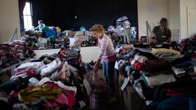 Volunteers arrange donated clothes at a centre that has been turned into an unofficial donation point in the town of Cobargo. A kitchen, laundry facilities and a food bank were set up, and medics, a counsellor and a chaplain joined to support the displaced. Meetings were held nightly and trucks rolled up daily, bringing water, food, animal feed and huge hay bales for farms. (Alkis Konstantinidis/REUTERS)