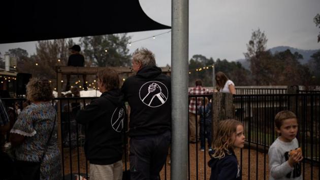 People attend a gathering in the town’s pub to commemorate the loss of three members of the community and honour the efforts of the local firefighters. Word quickly spread that a commune was forming. Caravans in tow, more evacuees arrived, among them farmers. (Alkis Konstantinidis/REUTERS)