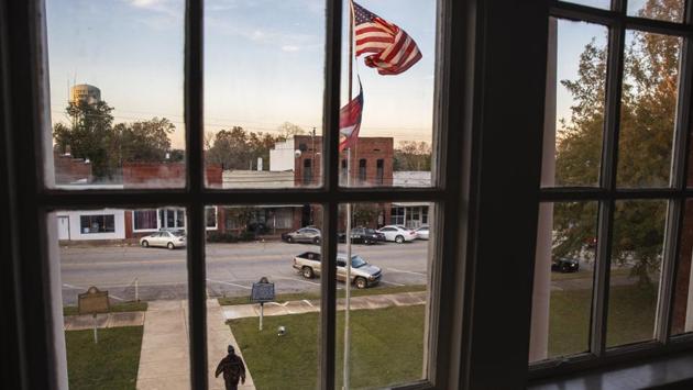 A resident leaves a meeting at the Stewart County courthouse on the town square. Lumpkin has few available resources—only three immigration lawyers work here full time. There are no hotels, and many businesses in the downtown are shuttered. In the vacuum, a small network has sprung up to help the immigrants, offering them legal advice, places for relatives to stay and even gas cards for the families. (David Goldman / AP)