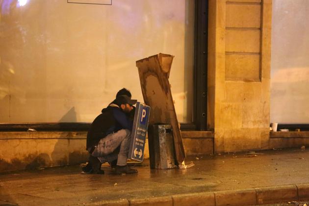 Lebanese protesters take cover amid clashes with riot police near the parliament. On Saturday, at least 377 people were wounded—both protesters and members of the security forces—according to a toll compiled by AFP from figures provided by the Red Cross and Civil Defence. Lawyers said more than 40 protesters were arrested on Saturday before being released. (Patrick Baz / AFP)