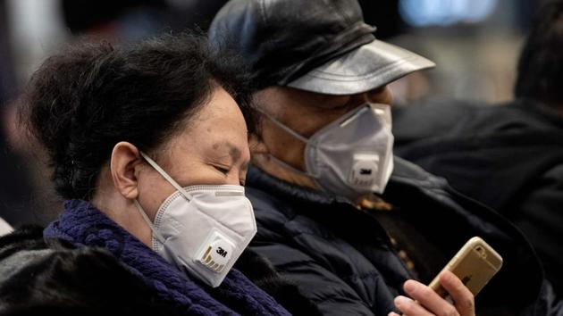 Travellers wearing protective rest on a bench after arriving at the Beijing Capital Airport in Beijing on January 21, 2020.(AFP file photo)