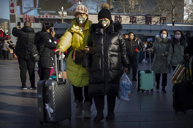 Travelers wear face masks as they walk outside of the Beijing Railway Station in Beijing. (AP) Travelers wear face masks as they walk outside of the Beijing Railway Station in Beijing. (AP)