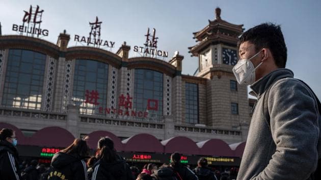 People wearing masks head for Beijing railway station. On the Weibo social media platform, which is widely used in China, people posted prevention advice such as wearing masks and washing hands. Some people said they had cancelled their travel plans and were staying home for Lunar New Year. (Nicolas Asfouri / AFP)