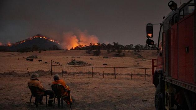Rural Fire Service volunteer firefighters watch as the New South Wales “megafire” approaches the outskirts of the town of Tumbarumba. Australia has since October been overwhelmed by an unprecedented bushfire season made worse by climate change. Swathes of the country have burned, hundreds of millions of animals have died, more than 2,000 homes destroyed and at least 29 lives lost. (Greenpeace / AFP)