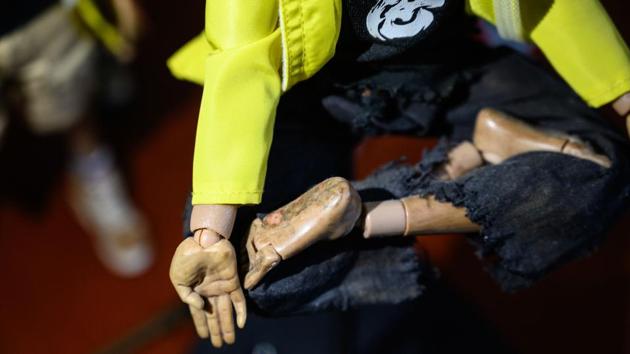 Details of injury scars on an action figure. Some figurines have scrapes on their legs from street skirmishes and almost all have removable gas masks that have become ubiquitous during the protests. “We want to make them as detailed as possible so that they can evoke empathy in people,” Charlie said. (Philip Fong / AFP) 