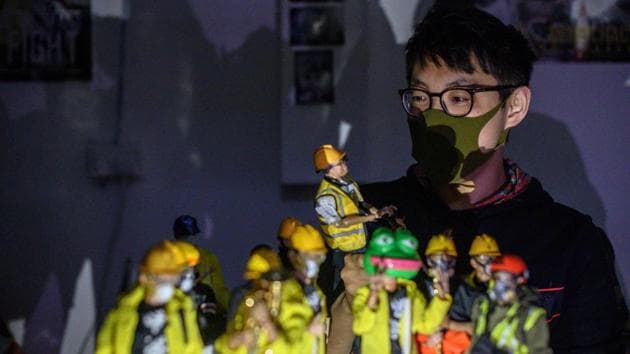 Figurine enthusiast Charlie, who asked to use a pseudonym, posing with action figures depicting characters involved in the Hong Kong protests. This local figurine enthusiast and his friend designed dozens of characters based on their own experiences of attending months of protests. “We hope the figurines can reconstruct the situation with authenticity,” Charlie, a 30-year-old freelance photographer by day told AFP. (Philip Fong / AFP) 