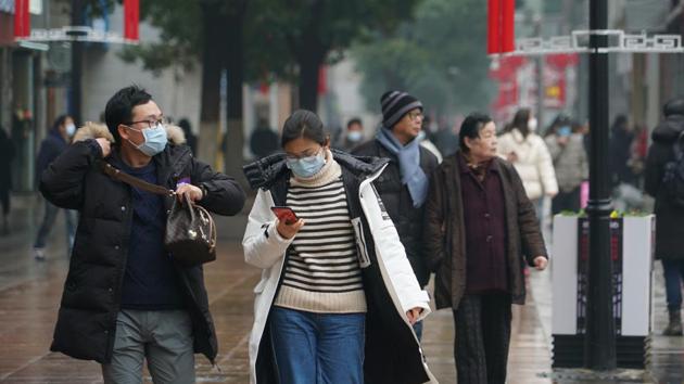 Masked pedestrians walk down a shopping street in downtown Wuhan, China January 22, 2020. The number of cases of a new coronavirus from Wuhan has risen over 400 in China and the death toll to 9, Chinese health authorities said Wednesday, Jan 22, 2020.(AP)