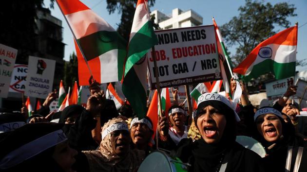 Demonstrators hold placards and national flags during a protest against a new citizenship law in Mumbai, India.(REUTERS)