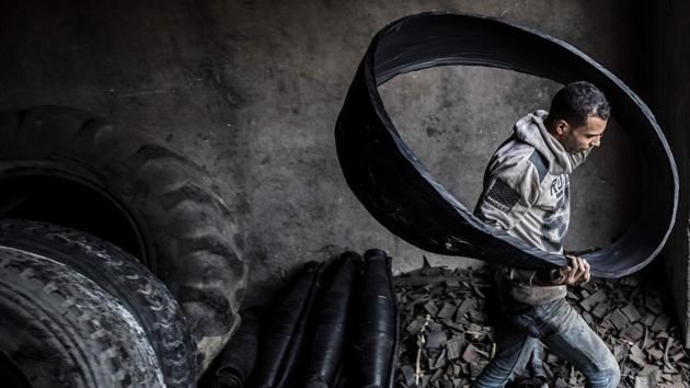 A labourer carries a ripped-out tyre liner. At another workshop, 43-year-old Mostafa Azab fashions baskets out of tyres from trucks, tractors and industrial vehicles. (Khaled Desouki / AFP) A labourer carries a ripped-out tyre liner. At another workshop, 43-year-old Mostafa Azab fashions baskets out of tyres from trucks, tractors and industrial vehicles. (Khaled Desouki / AFP)