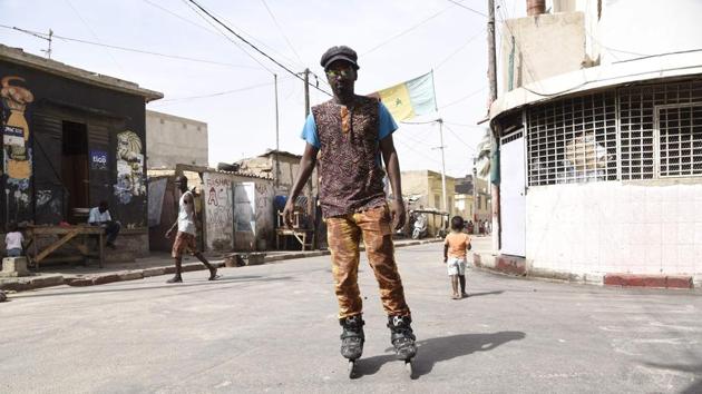Mamadou Boye Diallo, an art curator with a penchant for heart-shaped glasses, calls Dakar’s working-class Medina neighbourhood an open-air museum. Flitting on rollerblades between colourful murals in this part of the West African metropolis, Diallo, who is also a guide to the area, points to works by artists from all over the world. (Seyllou / AFP)