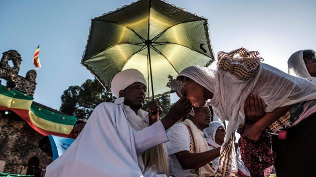 A devotee kisses a cross during Timkat, generally a sunny and joyous affair—and one that offers a choice meeting ground for young singles on the hunt for romance. Multiple factors make it ideal for finding a partner, Aschalew Worku, the top tourism official in Gondar told AFP. First, the holiday comes at the height of wedding season, meaning love is already in the air. (Eduardo Soteras / AFP) A devotee kisses a cross during Timkat, generally a sunny and joyous affair—and one that offers a choice meeting ground for young singles on the hunt for romance. Multiple factors make it ideal for finding a partner, Aschalew Worku, the top tourism official in Gondar told AFP. First, the holiday comes at the height of wedding season, meaning love is already in the air. (Eduardo Soteras / AFP)