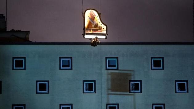 Swiss artist Alain Roche plays the piano hanging from a crane during a concert at a construction site in Munich, Germany. (Michael Dalder / REUTERS) Swiss artist Alain Roche plays the piano hanging from a crane during a concert at a construction site in Munich, Germany. (Michael Dalder / REUTERS)