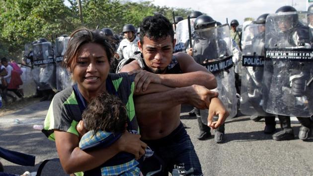 Migrants, mainly from Central America and marching in a caravan, react as members of the security forces approach them, near Frontera Hidalgo, Chiapas, Mexico. (Andres Martinez Casares / REUTERS) Migrants, mainly from Central America and marching in a caravan, react as members of the security forces approach them, near Frontera Hidalgo, Chiapas, Mexico. (Andres Martinez Casares / REUTERS)