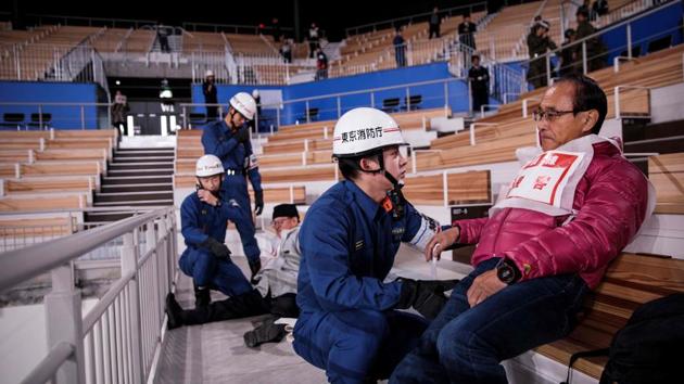 Within minutes, blue uniformed officers from the Tokyo fire department in their white helmets stream into the stadium. “Are you OK?” emergency first responders shout as they tend to bodies littering the stands. Officials urge calm via loudspeakers and console elderly spectators. (Behrouz Mehri / AFP)