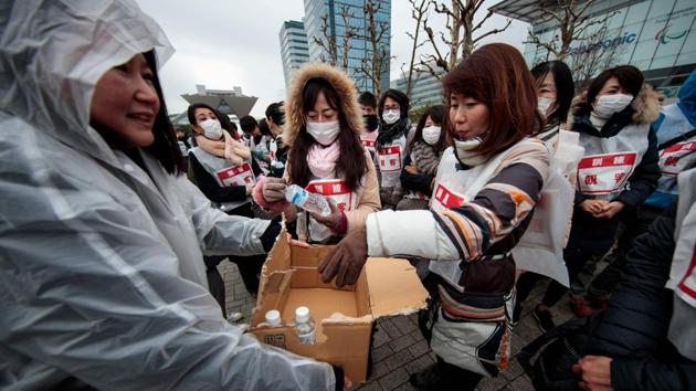 A staff member distribute water to the mock evacuees. While visitors may be unnerved by earthquakes, officials stress there is no country better prepared or equipped. Japan experiences thousands of tremors per year and the vast majority cause little or no damage. (Behrouz Mehri / AFP)