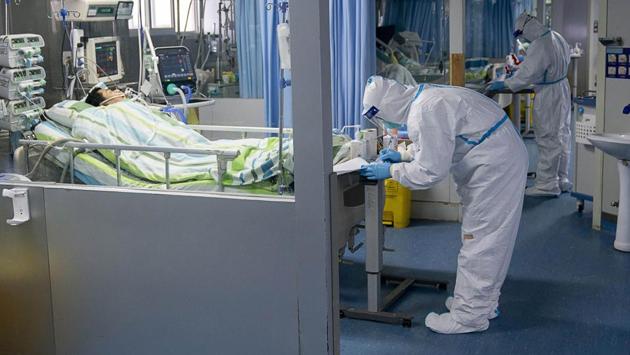 A medical worker attends to a patient in the intensive care unit at Zhongnan Hospital at Wuhan University. The number of confirmed cases around the world climbed sharply to 1300, with at least 41 deaths on Friday. (Xiong Qi / Xinhua via AP)