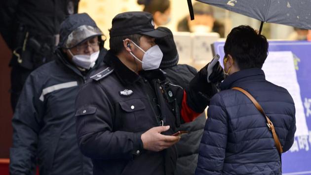 A policeman wearing a face mask takes a tourist's temperature at the Qinhuai scenic zone in Nanjing in eastern China's Jiangsu province.(AP)