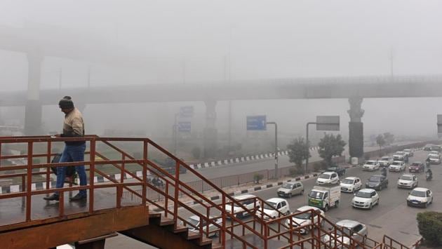 A view of traffic amid dense fog on a cold morning at Dhaula Kuan in New Delhi. (Sanchit Khanna / HT Photo) 