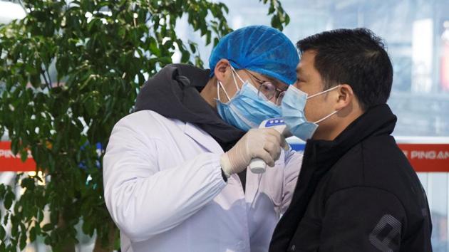 A medical official takes the body temperature of a man at the departure hall of the airport in Changsha, Hunan Province, as the country is hit by an outbreak of a new coronavirus.(REUTERS) A medical official takes the body temperature of a man at the departure hall of the airport in Changsha, Hunan Province, as the country is hit by an outbreak of a new coronavirus.(REUTERS)