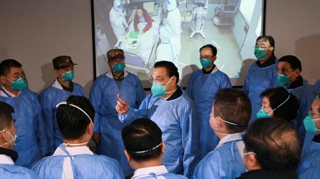 Chinese Premier Li Keqiang wearing a mask and protective suit speaks to medical workers as he visits the Jinyintan hospital where the patients of the new coronavirus are being treated following the outbreak, in Wuhan.(REUTERS)
