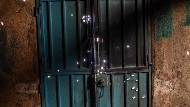 View of bullet holes on the door of an abandoned home in the village of El Paraiso de Tepila. The children practice with rifles and handguns or makeshift weapons in various drill positions for a few hours every week. “Position three!” yells instructor Bernardino Sanchez, a member of the militia responsible for the security of 16 villages in the Guerrero area, which goes by the name of Regional Coordinator of Community Authorities (CRAC-PF). (Pedro PARDO / AFP) View of bullet holes on the door of an abandoned home in the village of El Paraiso de Tepila. The children practice with rifles and handguns or makeshift weapons in various drill positions for a few hours every week. “Position three!” yells instructor Bernardino Sanchez, a member of the militia responsible for the security of 16 villages in the Guerrero area, which goes by the name of Regional Coordinator of Community Authorities (CRAC-PF). (Pedro PARDO / AFP)