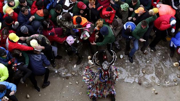 People throw turnips at the Jarramplas as he makes his way through the streets beating his drum during the Jarramplas festival. The festival features a man in multicoloured garb and pointy wooden headgear to shield himself from turnips. A crowd of men in the street pelt the man with the vegetables from close range at the fiesta held annually at Piornal, 200 kilometers west of Madrid, over two days. (Manu Fernandez / AP)