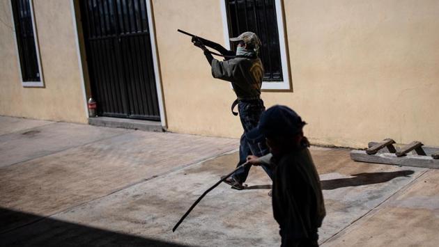 Guerrero governor Hector Astudillo on Friday made his first appearance in the region since taking office four years ago. He took the opportunity to criticize the training of children and negotiate with the militia over lifting roadblocks. Many children “have lost their parents,” said Bernardino, who does not want to see others traumatized by the murder of their loved ones. On the basketball court, it is break time. The children grab a basketball and one aims for the frayed net, a too-large rifle slung behind his back. (Pedro PARDO / AFP) Guerrero governor Hector Astudillo on Friday made his first appearance in the region since taking office four years ago. He took the opportunity to criticize the training of children and negotiate with the militia over lifting roadblocks. Many children “have lost their parents,” said Bernardino, who does not want to see others traumatized by the murder of their loved ones. On the basketball court, it is break time. The children grab a basketball and one aims for the frayed net, a too-large rifle slung behind his back. (Pedro PARDO / AFP)