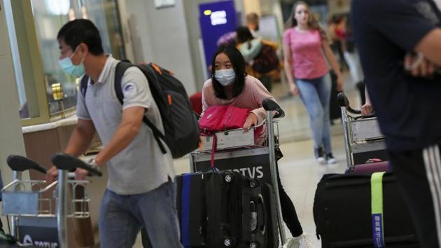 Travellers, wearing masks as a precautionary measure to avoid contracting coronavirus, arrive on a flight from China at Guarulhos International Airport in Guarulhos, Sao Paulo state, Brazil.(REUTERS)