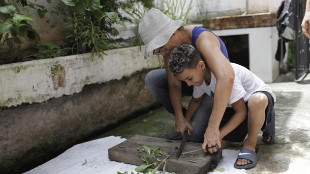 Ale Roque teaches a boy to garden. The city has begun paying attention. Rio this month started planting native tree species to create 25 “fresh islands” in the city’s West Zone. Meantime, it’s only getting hotter in Brazil, as in the rest of the world. Its south-east region -- where Rio is located — has recorded three of its steamiest five years on record since 2014. (Silvia Izquierdo / AP) Ale Roque teaches a boy to garden. The city has begun paying attention. Rio this month started planting native tree species to create 25 “fresh islands” in the city’s West Zone. Meantime, it’s only getting hotter in Brazil, as in the rest of the world. Its south-east region -- where Rio is located — has recorded three of its steamiest five years on record since 2014. (Silvia Izquierdo / AP)