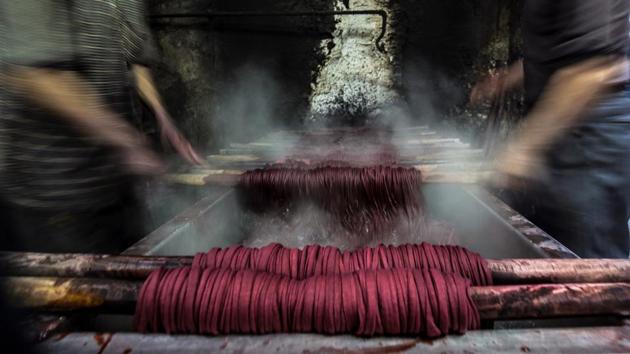Workers spin dyed yarns from a vat at the Salama workshop. “We rinse the wet threads before flattening them out in an electric presser and then leave them out to dry,” Salama added. (Khaled Desouki / AFP) Workers spin dyed yarns from a vat at the Salama workshop. “We rinse the wet threads before flattening them out in an electric presser and then leave them out to dry,” Salama added. (Khaled Desouki / AFP)