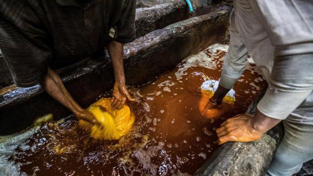 Workers dye yarns in a dyebath. They have no gloves or masks to protect them from the dyes and fumes. (Khaled Desouki / AFP) Workers dye yarns in a dyebath. They have no gloves or masks to protect them from the dyes and fumes. (Khaled Desouki / AFP)