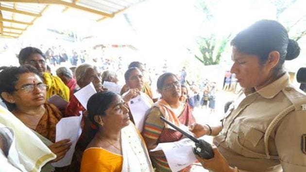 A police personnel checks the age proof of women devotees at the Pamba base camp of Sabarimala Temple(Vivek R Nair / HT File)