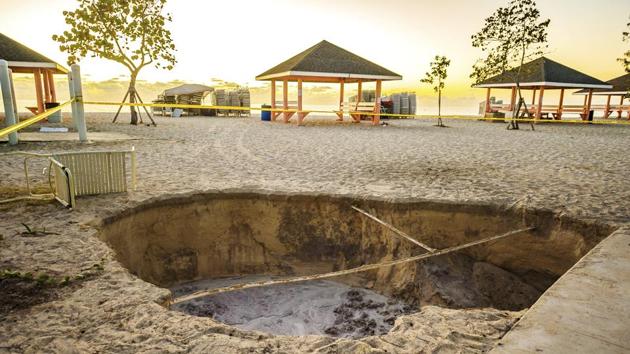 A sinkhole is surrounded by police tape after it appeared when a powerful magnitude 7.7 earthquake struck in the Caribbean Sea between Jamaica and eastern Cuba on Jan. 28, 2020.(AP) A sinkhole is surrounded by police tape after it appeared when a powerful magnitude 7.7 earthquake struck in the Caribbean Sea between Jamaica and eastern Cuba on Jan. 28, 2020.(AP)