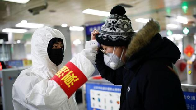 A staff member in Beijing checks the temperature of a passenger entering a subway station, as China is hit by an outbreak of the new coronavirus, on January 28.(Reuters Photo) A staff member in Beijing checks the temperature of a passenger entering a subway station, as China is hit by an outbreak of the new coronavirus, on January 28.(Reuters Photo)