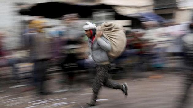 A labourer runs across a wholesale market in the old quarters of Delhi.(Photo: Reuters) A labourer runs across a wholesale market in the old quarters of Delhi.(Photo: Reuters)