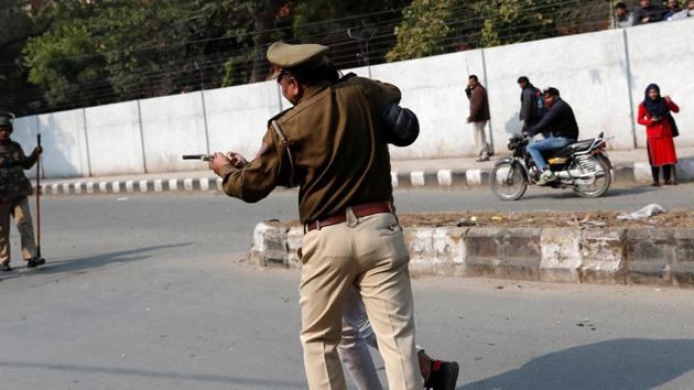 A police officer detains an unidentified man after he brandished a gun and injured a student during a protest against a new citizenship law outside the Jamia Millia Islamia university in New Delhi on January 30, 2020.(REUTERS)