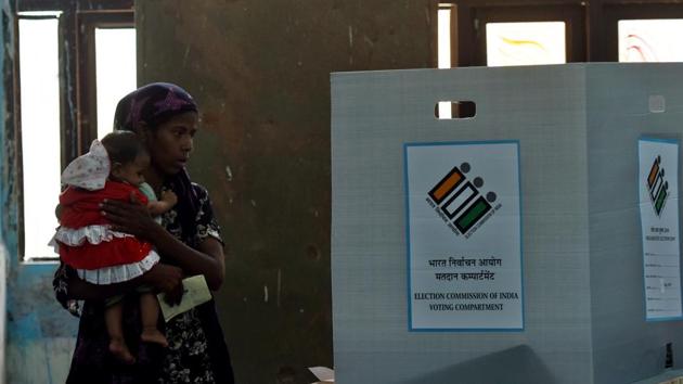 A voter, carrying her son, casts her vote during the repolling at Daryaganj, in Delhi.(Amal KS/HT PHOTO) A voter, carrying her son, casts her vote during the repolling at Daryaganj, in Delhi.(Amal KS/HT PHOTO)