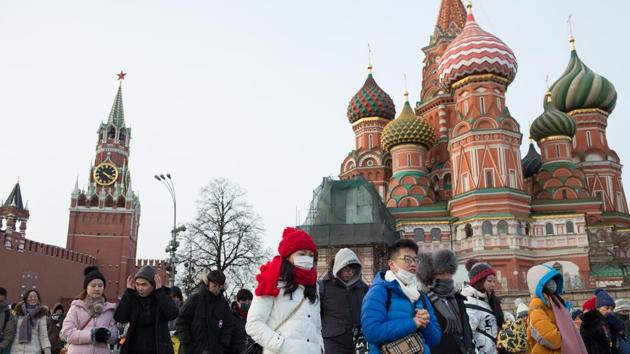 Tourists wear protective face masks as they walk in Red Square near the Kremlin in Moscow.(Bloomberg) Tourists wear protective face masks as they walk in Red Square near the Kremlin in Moscow.(Bloomberg)