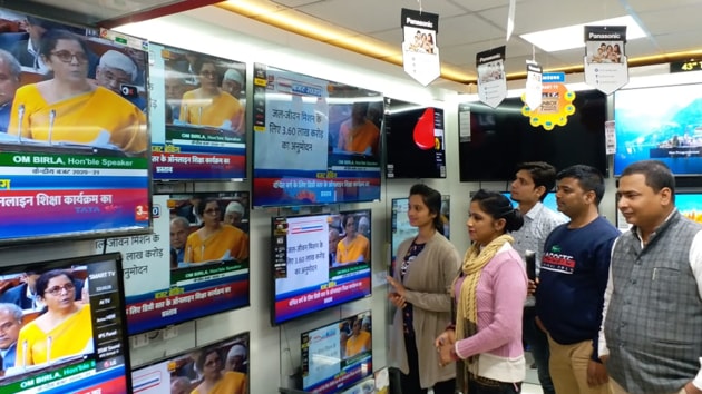 People watching budget by finance minister at a showroom. (Photo A P Dube/HT)