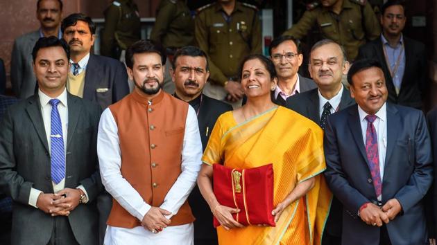 New Delhi: Union Finance Minister Nirmala Sitharaman, holding a folder containing the Union Budget documents, poses for photographers along with her deputy Anurag Thakur and a team of officials, outside the Ministry of Finance, North Block in New Delhi, Saturday, Feb. 1, 2020.(PTI) New Delhi: Union Finance Minister Nirmala Sitharaman, holding a folder containing the Union Budget documents, poses for photographers along with her deputy Anurag Thakur and a team of officials, outside the Ministry of Finance, North Block in New Delhi, Saturday, Feb. 1, 2020.(PTI)