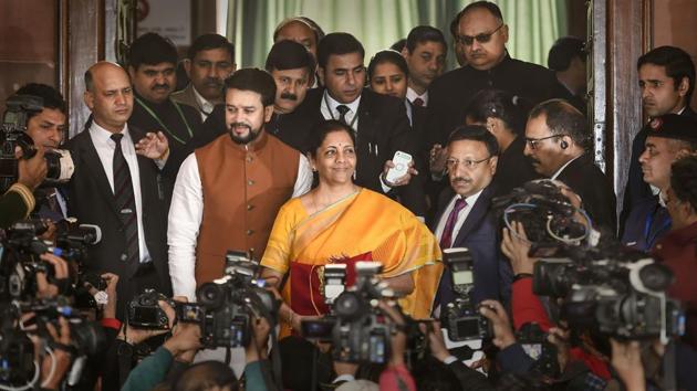 New Delhi: Union Finance Minister Nirmala Sitharaman, flanked by her deputy Anurag Thakur (to her right) and a team of officials, shows a folder containing the Union Budget documents, as she poses for lensmen on her arrival at Parliament in New Delhi, Saturday, Feb. 1, 2020.(PTI)