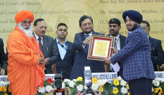 Chief Justice of India Sharad Arvind Bobde (centre) felicitating philanthropist SPS Oberoi as environmentalist Balbir Singh Seechewal (extreme left) looks on during the international conference on ‘Philosophy of Guru Nanak Dev and its relevance today in equity, social justice and environment’ at Gymnasium Hall in Panjab University on Saturday.(Anil Dayal/HT)