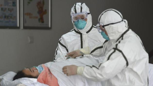 Medical workers in protective suits move a coronavirus patient into an isolation ward at the Second People's Hospital in Fuyang in central China's Anhui Province. (AP) Medical workers in protective suits move a coronavirus patient into an isolation ward at the Second People's Hospital in Fuyang in central China's Anhui Province. (AP)