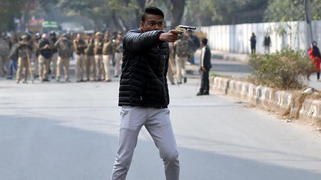 An unidentified man brandishes a gun during a protest against the CAA and NRC outside the Jamia Millia Islamia university in New Delhi. (Danish Siddiqui / REUTERS)