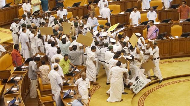 Security personnel help Kerala Governor Arif Mohammed Khan as he is blocked by protesting opposition legislators on his arrival into the house for governor’s address, in Thiruvananthapuram, Kerala. (PTI)