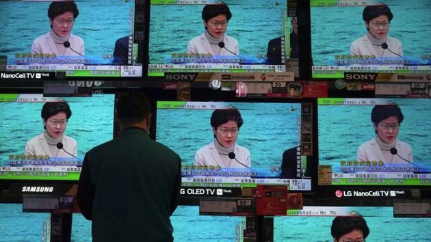 A man wears protective face masks stands in front of TV screens broadcasting Hong Kong Chief Executive Carrie Lam delivering a speech in Hong Kong. (AP) A man wears protective face masks stands in front of TV screens broadcasting Hong Kong Chief Executive Carrie Lam delivering a speech in Hong Kong. (AP)
