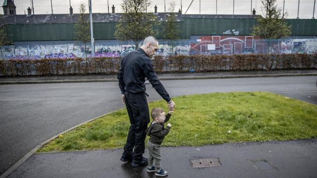 David Reid, 33, walks with his son Lawson, 1, in front of their home bordering a wall separating their Protestant neighbourhood from a Catholic one, in Belfast, Northern Ireland. “It will go back to the troubles then because there be too many fighting on the street if it was a united Ireland,” said Reid. (David Goldman / AP) David Reid, 33, walks with his son Lawson, 1, in front of their home bordering a wall separating their Protestant neighbourhood from a Catholic one, in Belfast, Northern Ireland. “It will go back to the troubles then because there be too many fighting on the street if it was a united Ireland,” said Reid. (David Goldman / AP)